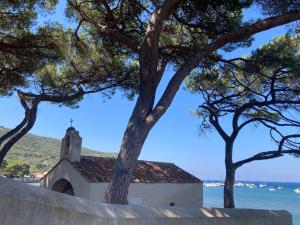 uma igreja com árvores em frente à água em CASA GINESTRA em Campiglia Marittima