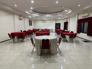 uma grande sala com mesas vermelhas e cadeiras em Hotel Winong Asri em Pati