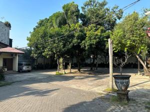 a street with trees and a vase on a pole at Hotel Winong Asri in Pati