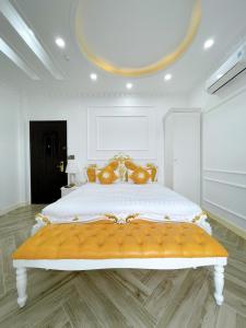 a large white bedroom with a large bed with orange pillows at Paris Hotel & Cafe in Vĩnh Long