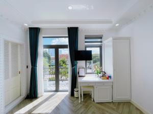 a white room with a desk and a window at Paris Hotel & Cafe in Vĩnh Long +30 photos