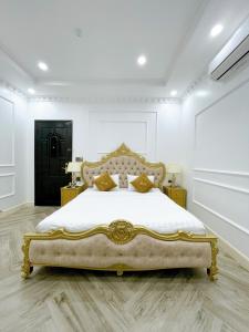 a bedroom with a king sized bed with golditures at Paris Hotel & Cafe in Vĩnh Long