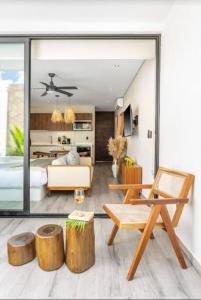 a living room with a bed and a room with logs at Modern Urban Jungle with Luxury Mayan Style in Tulum
