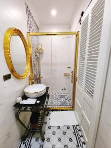 y baño con lavabo y ducha con espejo. en Paris Hotel & Cafe, en Vĩnh Long