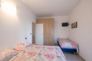 a bedroom with two beds and a closet at BILOCALE FRONTE MARE in Rimini