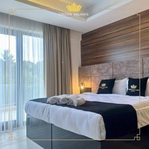 a bedroom with a large bed with a large window at Crown Salamis Hotel in Famagusta