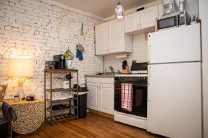 a kitchen with white cabinets and a white refrigerator at Studio Apt in Time Square! in New York