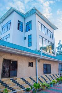 a large white building with a blue roof at Mzunguu Safari Lodge in Usa River