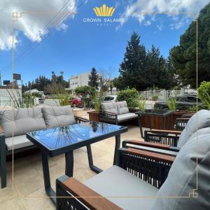 a patio with couches and tables on a patio at Crown Salamis Hotel in Famagusta
