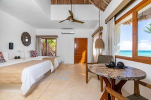 a bedroom with two beds and a table at Mahekal Beach Front Resort & Spa in Playa del Carmen