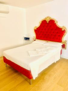 een groot bed met een rood hoofdeinde in een kamer bij Le Stanze del Brigante in Genua