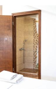 a shower in a bathroom with a glass door at Villa Elva in Ammoudia
