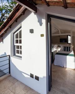 a bedroom in a house with a bed and a window at Sandi Hotel in Paraty