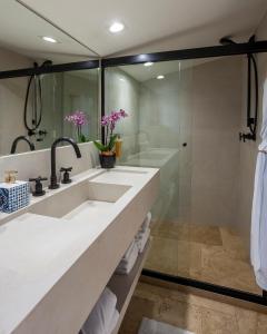 y baño con lavabo y ducha. en Sandi Hotel en Paraty