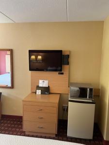 a room with a microwave and a television on a wall at Serenity Inn Sweetwater in Sweetwater