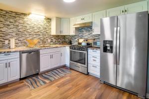 a kitchen with white cabinets and a stainless steel refrigerator at Cookson Vacation Rental with Spacious Yard and Porch! in Cookson