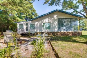 a tiny house in a yard with a fence at Cookson Vacation Rental with Spacious Yard and Porch! in Cookson