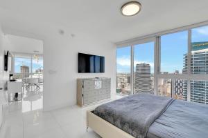 Dormitorio blanco con cama y ventana grande en PENTHOUSE 2BR ICON WHOTEL Brickell Miami, en Miami