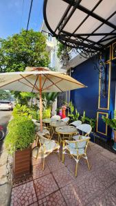 a patio with tables and chairs and an umbrella at Paris Hotel & Cafe in Vĩnh Long