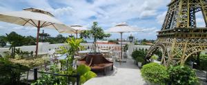 a balcony with tables and umbrellas and the eiffel tower at Paris Hotel & Cafe in Vĩnh Long