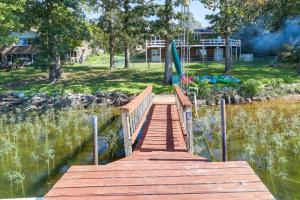 a wooden bridge over a body of water with a umbrella at Lakefront Arkansas Escape with Grill, Dock and Kayaks! in Horseshoe Bend
