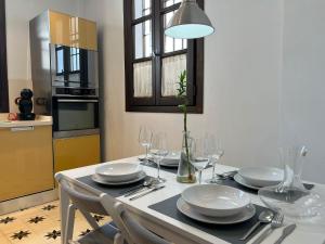 ein Esstisch mit Tellern und Weingläsern in der Unterkunft Casa Remanso de la Judería in Córdoba