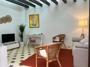 ein Wohnzimmer mit Sofa und Fernseher in der Unterkunft Casa Remanso de la Judería in Córdoba + 39 Fotos