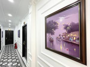 a large painting on the wall in a hallway at Paris Hotel & Cafe in Vĩnh Long