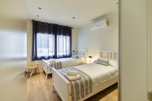 a bedroom with two beds and a window at APARTAMENTO VELA in Blanes