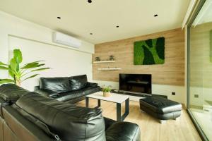 a living room with a leather couch and a fireplace at APARTAMENTO VELA in Blanes