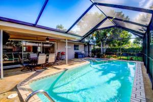 uma piscina com uma grande extensão de vidro para uma casa em Close to Siesta Key, Shopping, Restaurants & More! em Sarasota