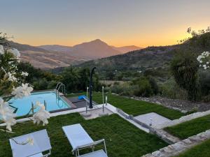 a villa with a swimming pool and mountains in the background at Casa del Sole in Polizzi Generosa