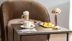 a table with a cup of coffee and two plates of food at Crown Salamis Hotel in Famagusta