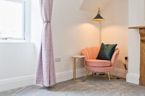 a living room with a chair and a lamp at Ty Calon - 3 storey 1920s home, close to beach & the city- close to theatre- perfect for family & friend breaks or longer term for contractors, crew and cast in Swansea