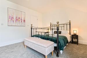 a bedroom with a bed and a bench in it at Ty Calon - 3 storey 1920s home, close to beach & the city- close to theatre- perfect for family & friend breaks or longer term for contractors, crew and cast in Swansea