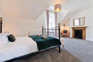 a bedroom with a bed and a fireplace at Ty Calon - 3 storey 1920s home, close to beach & the city- close to theatre- perfect for family & friend breaks or longer term for contractors, crew and cast in Swansea
