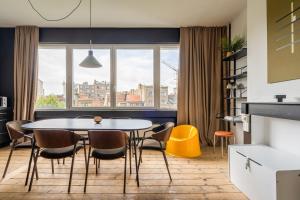 a dining room with a table and chairs and a window at Smartflats - the Brooklyn Antwerp in Antwerp