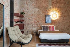 a room with two beds and a chair in it at Smartflats - the Brooklyn Antwerp in Antwerp