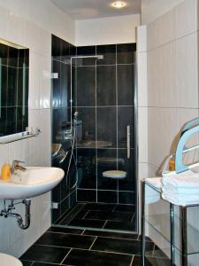 een badkamer met een glazen douche en een wastafel bij Pension Wehner in Torgau