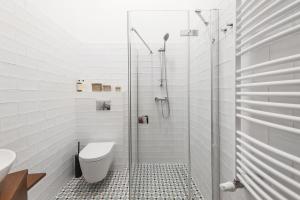 une salle de bain avec toilettes et douche en verre dans l'établissement Cracovian Home - LoftAffair, à Cracovie