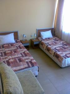 ein Zimmer mit 2 Betten und einem Sofa darin in der Unterkunft Sofia Family Hotel in Pomorie