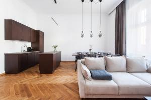 un salon avec un canapé blanc et une cuisine dans l'établissement Cracovian Home - LoftAffair, à Cracovie 21 autres photos