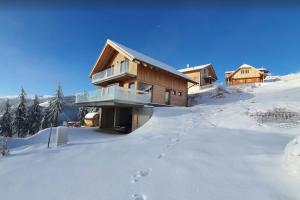 Klippitztorl的住宿－Chalet Luna，雪地中的小屋,雪地中留下脚印