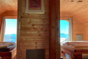 uma cabina de madeira com 2 camas e uma lareira em Chalet Luna em Klippitztorl