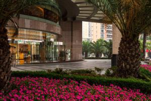 a building with pink flowers in front of it at Renaissance Shanghai Pudong Hotel in Shanghai
