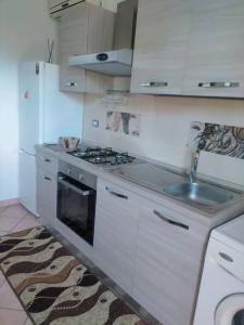 een witte keuken met een fornuis en een wastafel bij Appartamento per brevi periodi. in Scafati