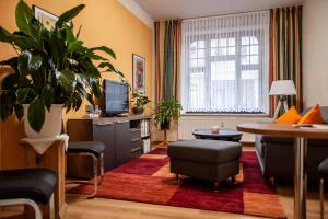 a living room with a television and a table and chairs at Pension Wehner in Torgau