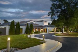 a building with lights on the side of a road at Courtyard Charlotte Arrowood in Charlotte