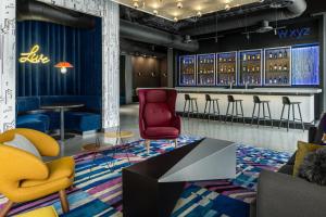 a lobby with chairs and a bar with wine bottles at Aloft San Pedro Sula in San Pedro Sula