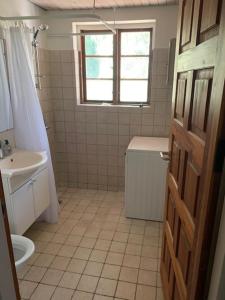 a bathroom with a sink and a toilet and a window at Dyrlundgård in Helsinge